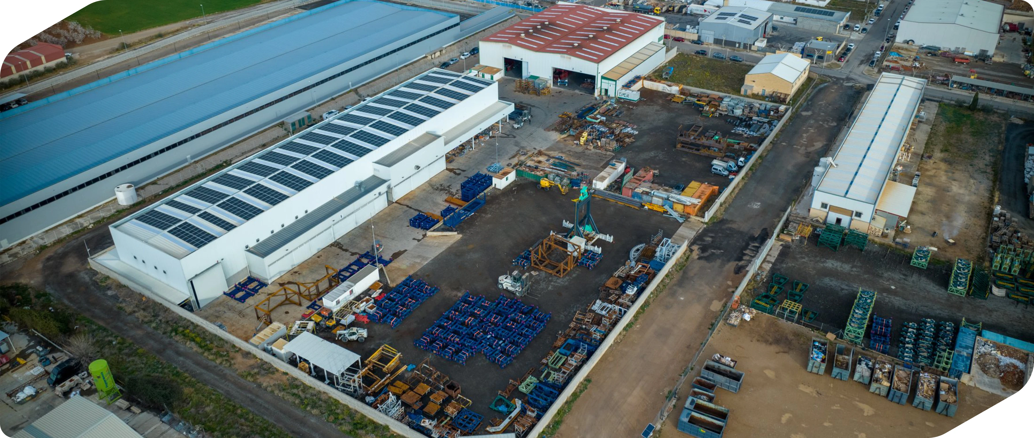 Vista aérea de una planta industrial con naves y zonas exteriores de acopio de piezas