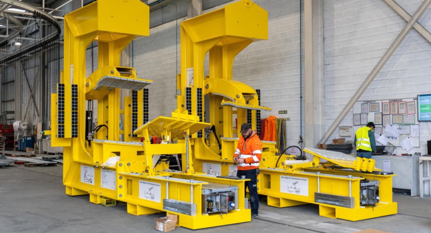 Útiles amarillos para la elevación de palas de aerogenerador en nave con operarios