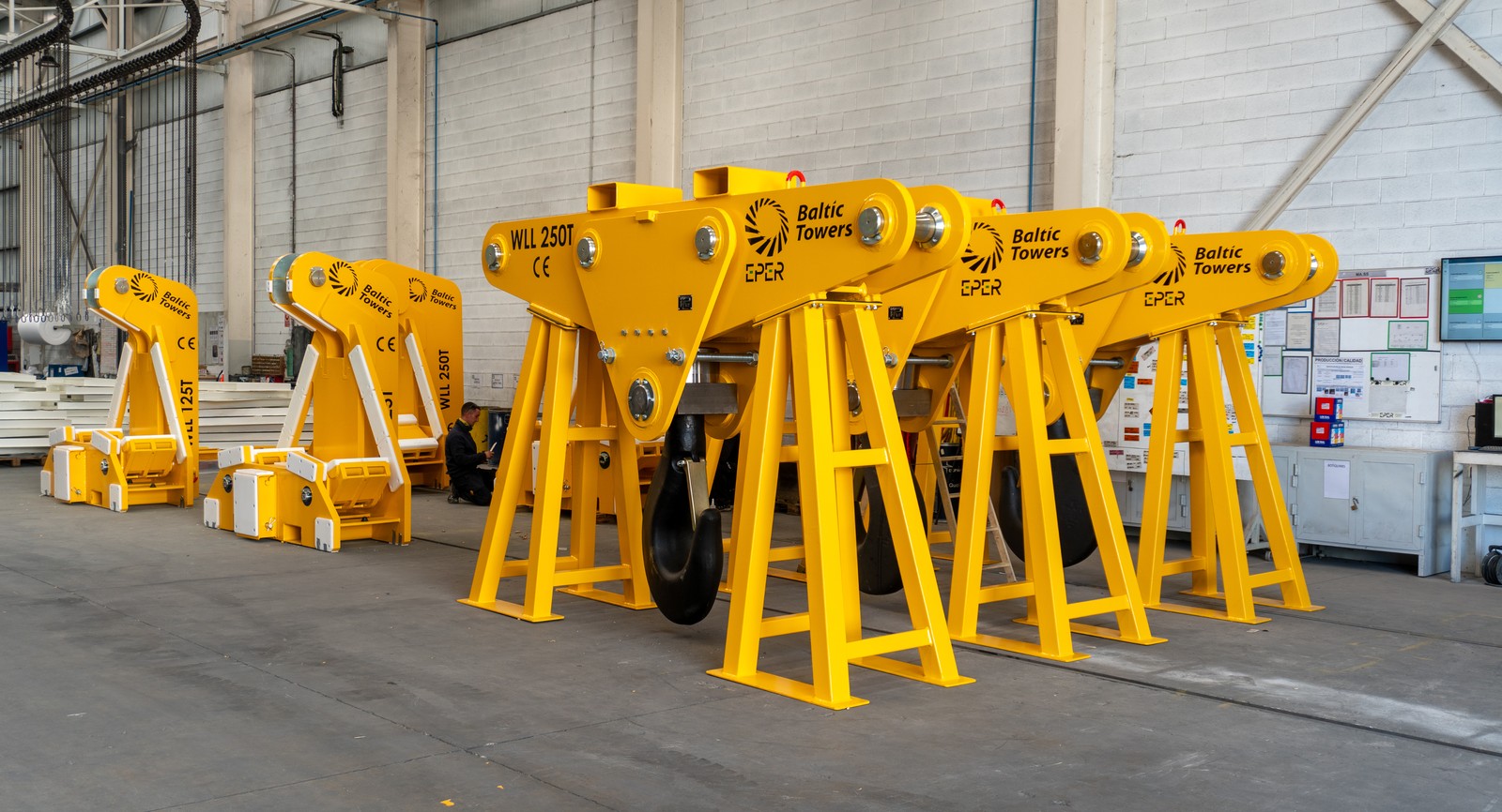 Ganchos de elevación en C y en J de color amarillo apoyados en nave