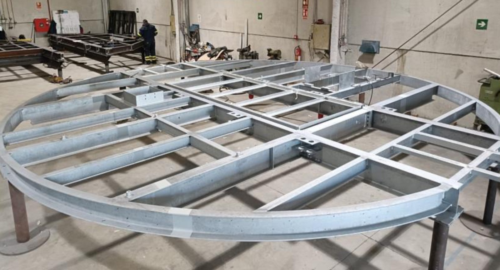 Plataforma metálica de trabajo circular con rejilla estructural en taller