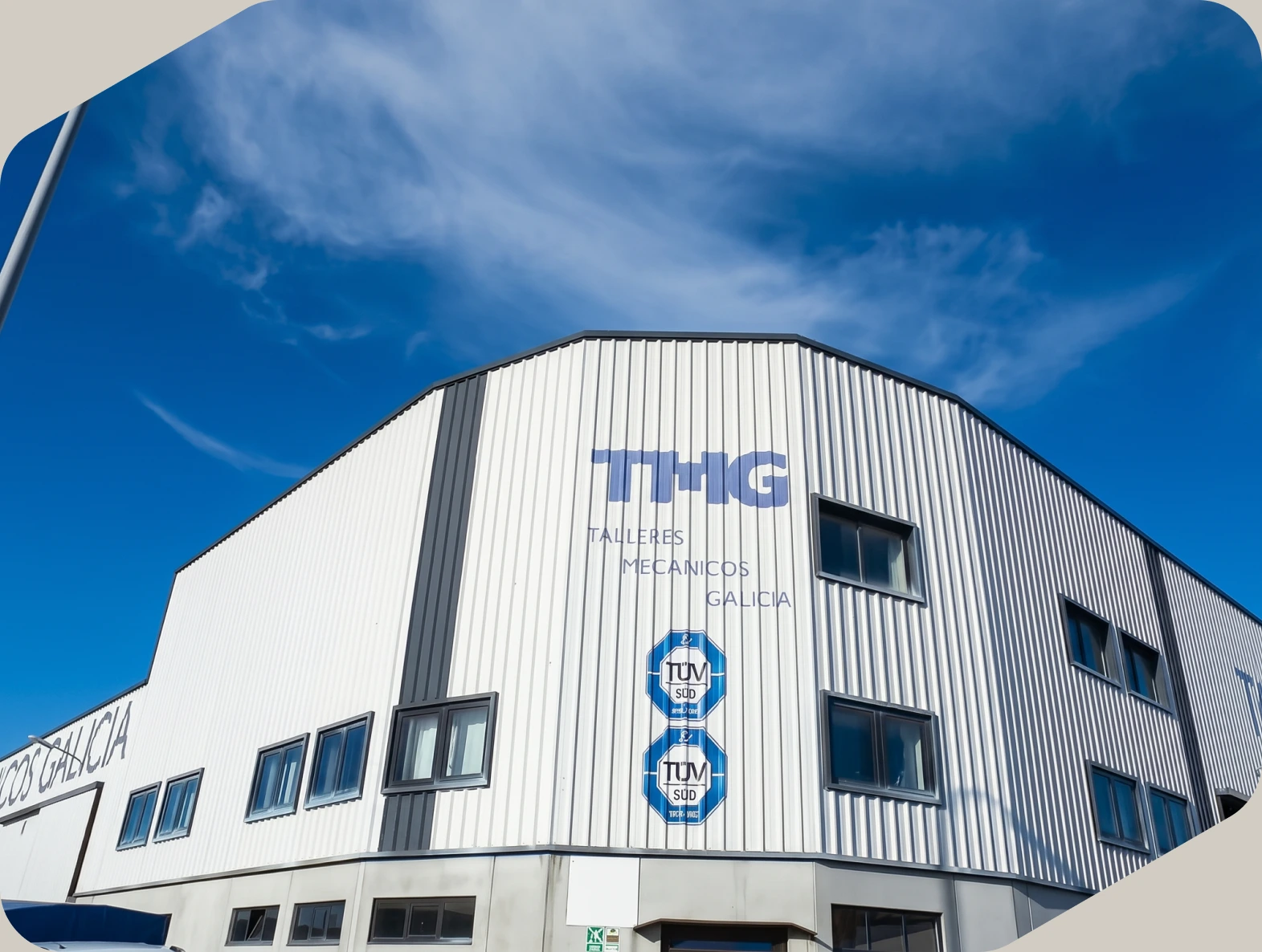 Fachada de la nave de TMG by EPER Group en Narón, A Coruña, bajo un cielo azul