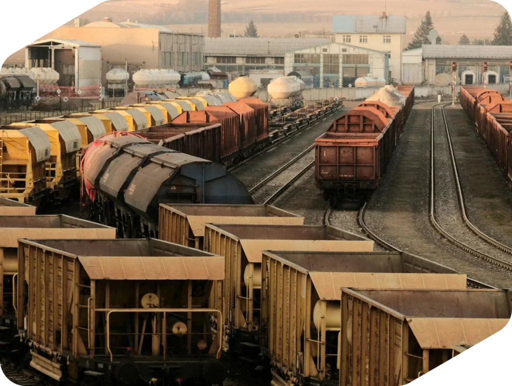 Vagones de mercancías y tolvas en una estación de maniobras al atardecer