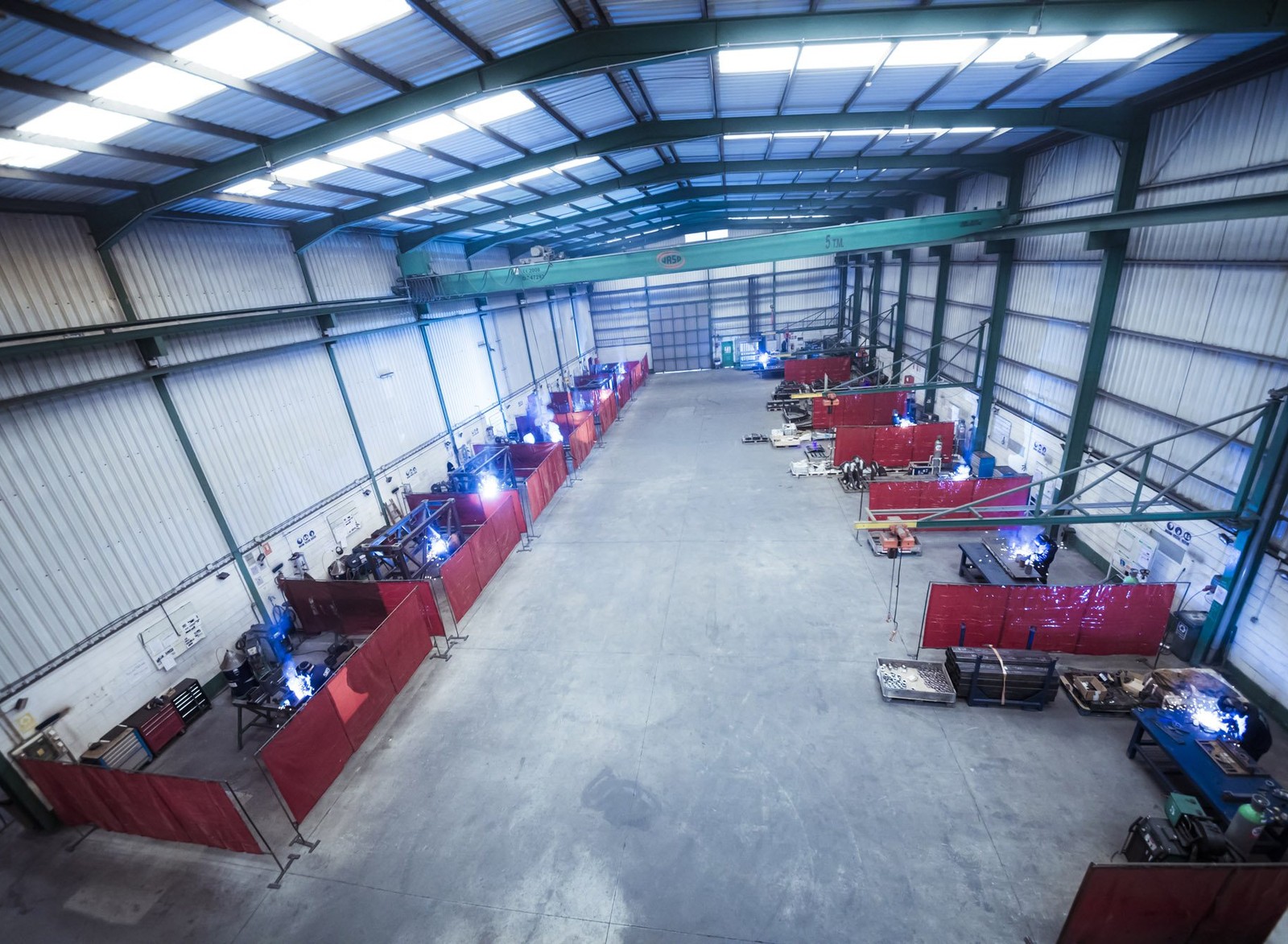 Nave de soldadura de EPER Group con múltiples puestos con cortinas rojas