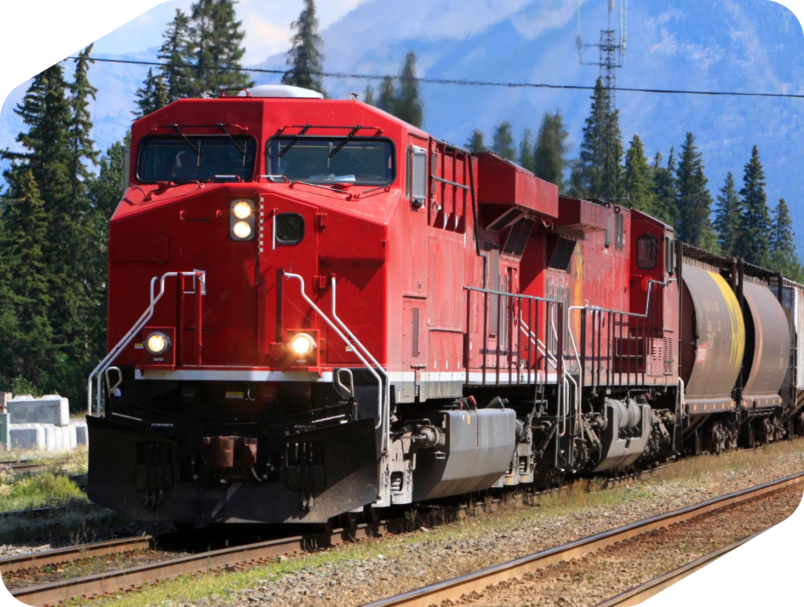 Locomotora roja arrastrando vagones de mercancías por una vía ferroviaria
