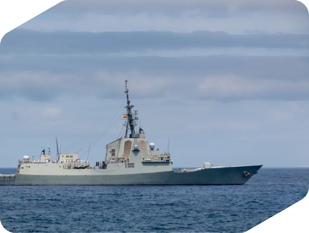Fragata gris navegando en mar abierto bajo un cielo nublado