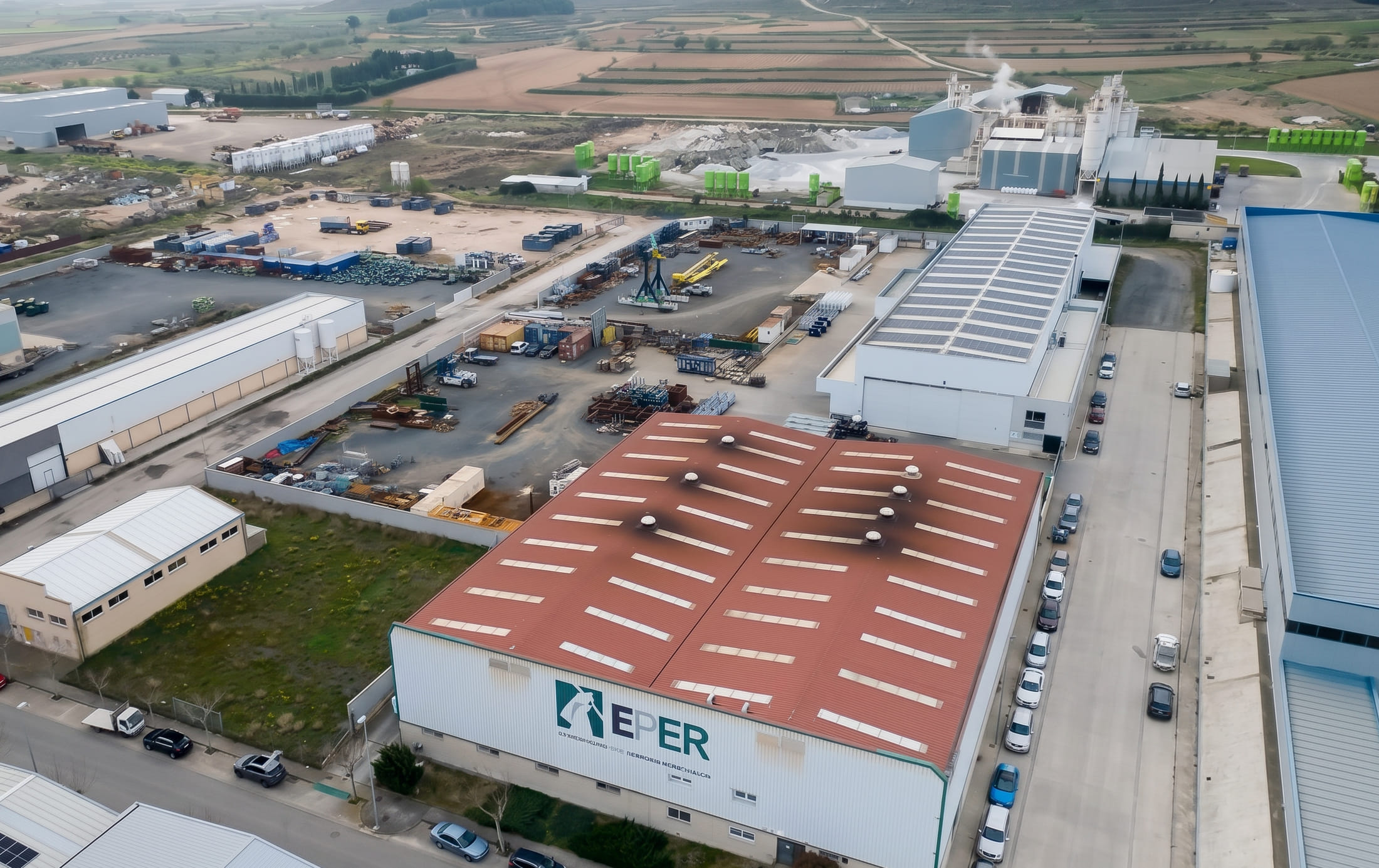 Vista aérea de la planta de EPER Group en Cintruénigo, Navarra, con su nave de cubierta roja y las naves colindantes