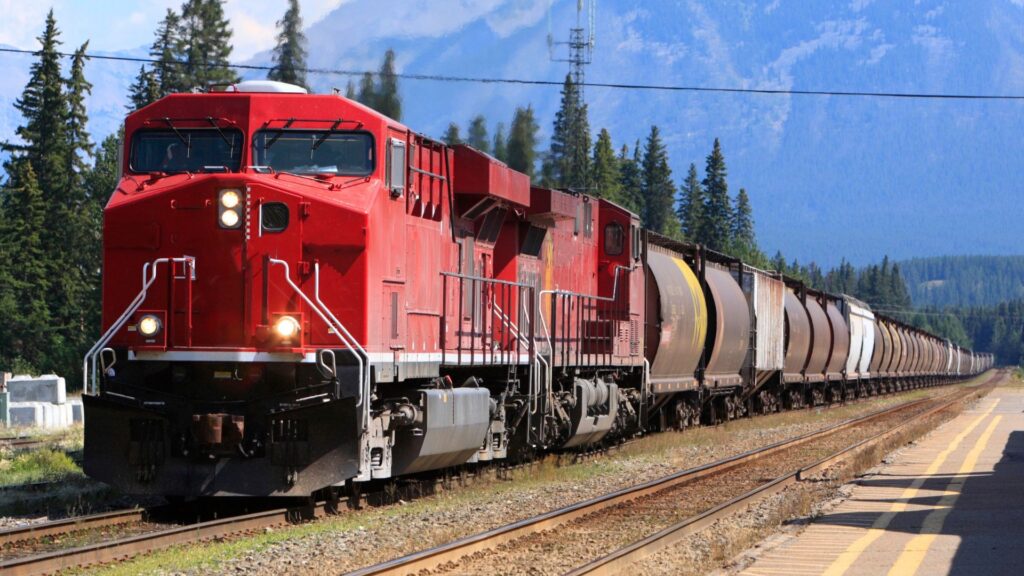 Locomotora roja con vagones cisterna en una vía férrea