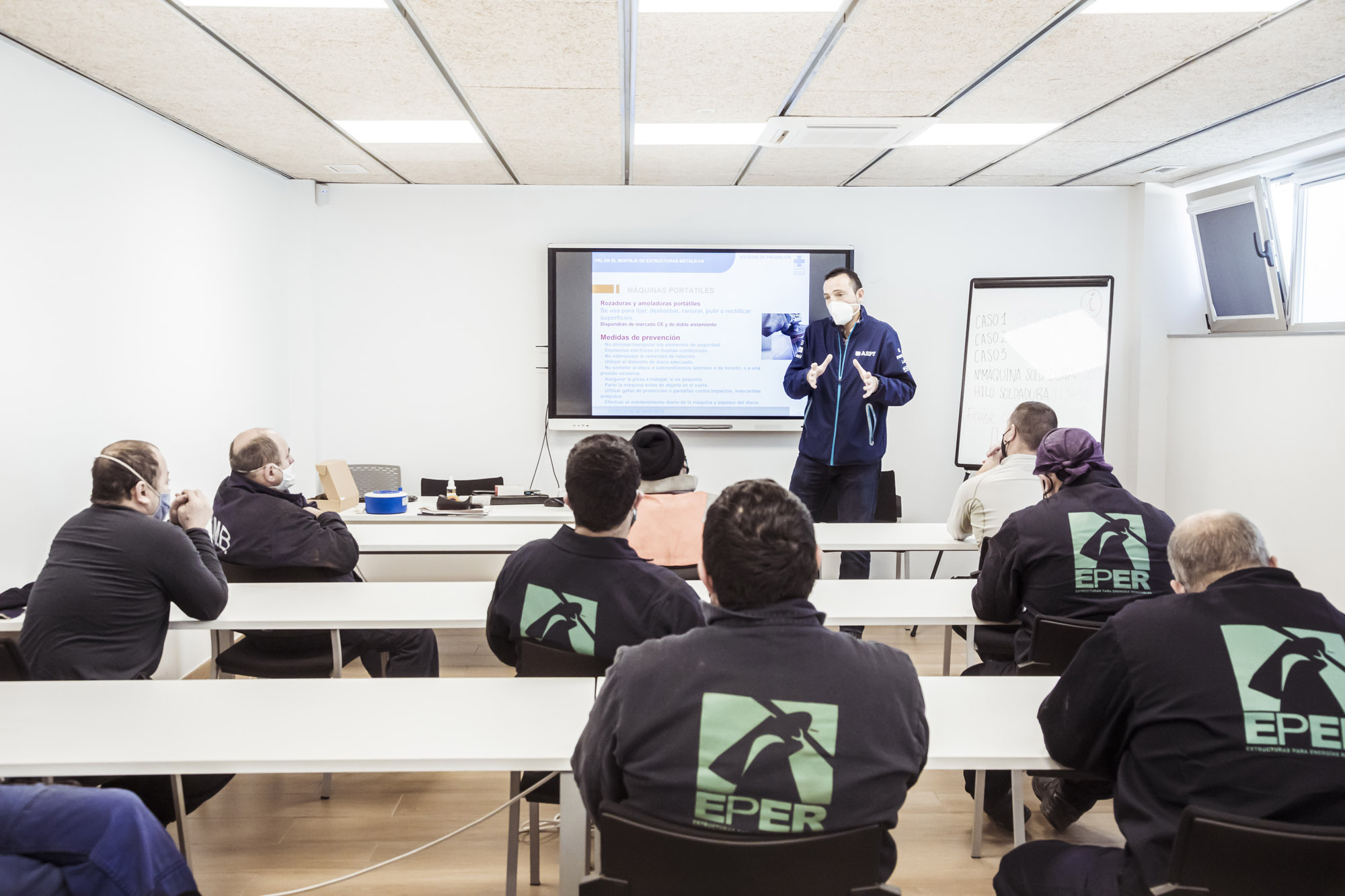 Formador presentando una sesión de formación a empleados sentados en un aula de EPER Group
