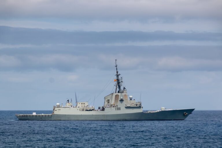Fragata gris navegando en mar abierto bajo un cielo nublado