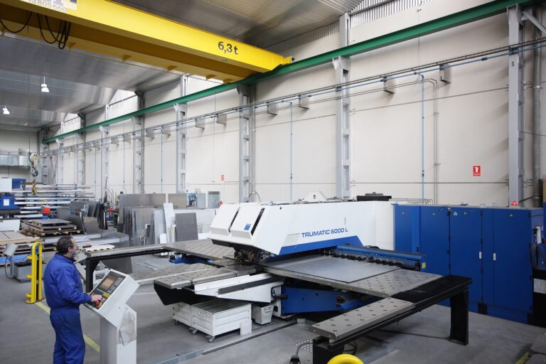 Operario manejando una punzonadora CNC en un taller de chapa