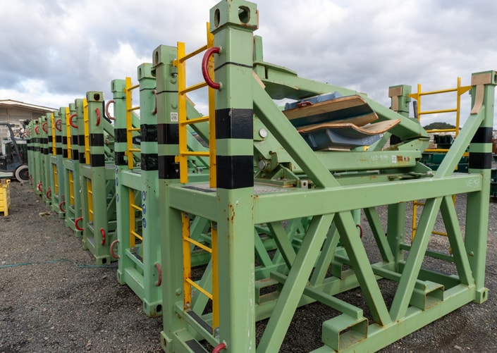 Estructuras metálicas de color verde apiladas en el exterior de la planta