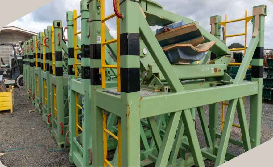 Estructuras metálicas verdes con barandillas amarillas alineadas en una nave